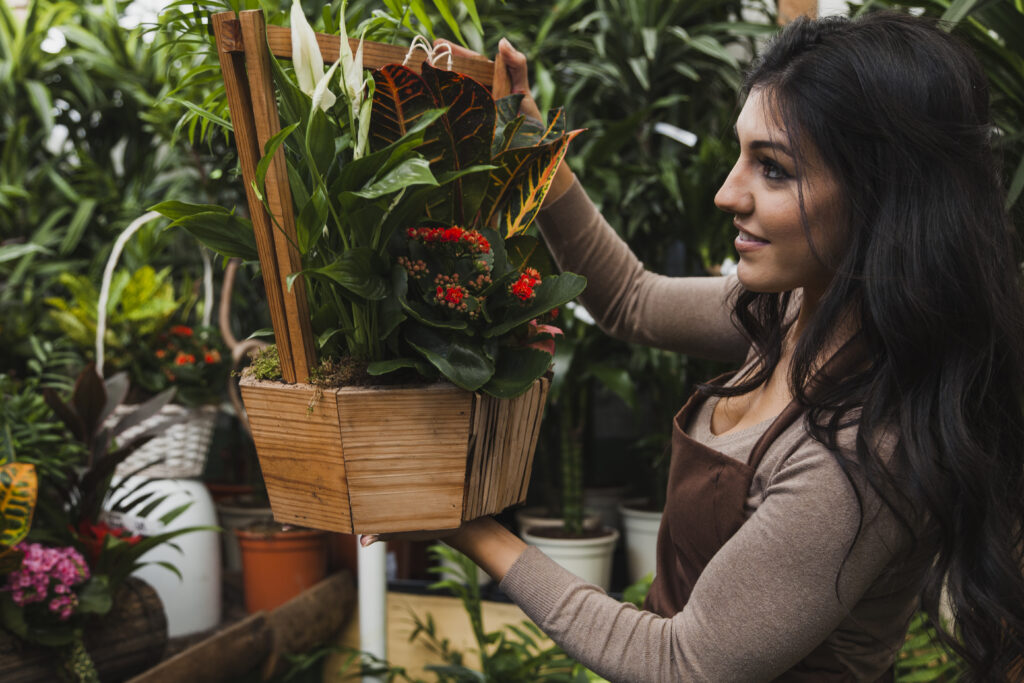 The current image has no alternative text. The file name is: woman-admiring-potted-plant-scaled.jpg