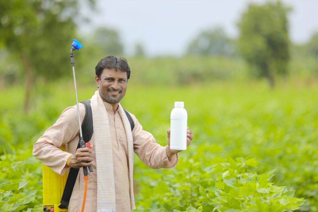 The current image has no alternative text. The file name is: young-indian-farmer-showing-liquid-fertilizer-bottle-agriculture-field-scaled.jpg